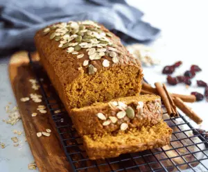 Freshly baked Pumpkin Oatmeal Bread topped with a sprinkle of oats, featuring a golden crust and moist, hearty interior perfect for fall breakfast or snack.