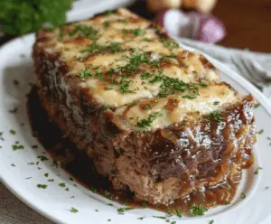 Savory French Onion Meatloaf topped with melted cheese and caramelized onions on a rustic plate