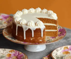 Delicious homemade pumpkin layer cake with cream cheese frosting and festive fall decorations