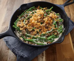 Delicious skillet green bean casserole with crispy fried onions and fresh green beans, perfect for festive dinners.