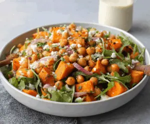 Colorful sweet potato chickpea salad with fresh greens and vibrant vegetables in a bowl, perfect for a healthy, gluten-free meal.