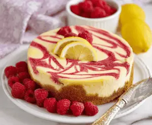 Creamy Lemon Raspberry Swirl Cheesecake with Fresh Fruit Topping