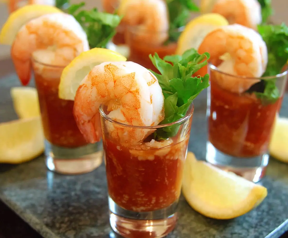 Delicious shrimp cocktail shooters served in elegant glassware, perfect for parties and special occasions.