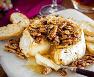 Delicious baked Brie cheese topped with honey and chopped nuts, perfect for appetizers.