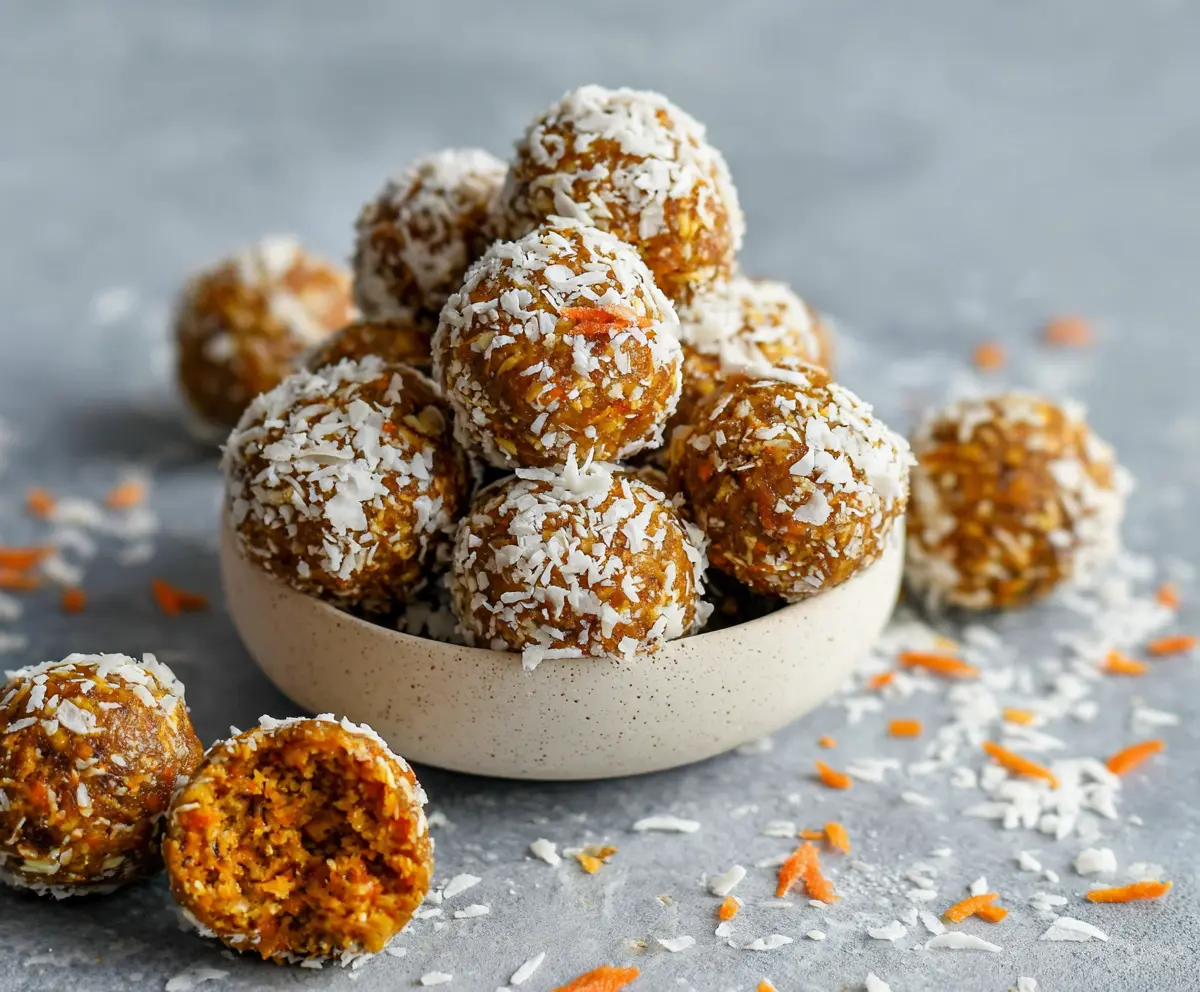 Healthy carrot cake energy bites with grated carrots and nuts in a clear bowl