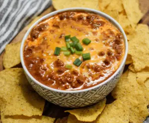 Creamy chili cheese dip served with tortilla chips, perfect for parties and gatherings.