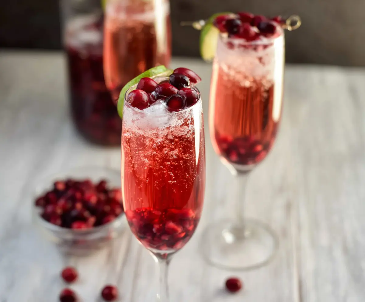 Vibrant Cranberry Prosecco Pomegranate Cocktail served in a elegant glass with fresh cranberries and pomegranate seeds.