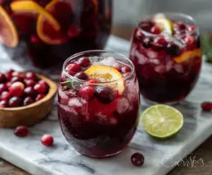 Refreshing cranberry sangria in a glass garnished with fresh cranberries and orange slices.