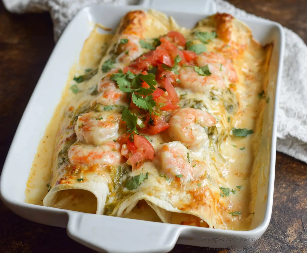 Delicious creamy shrimp enchiladas topped with melted cheese and fresh cilantro.