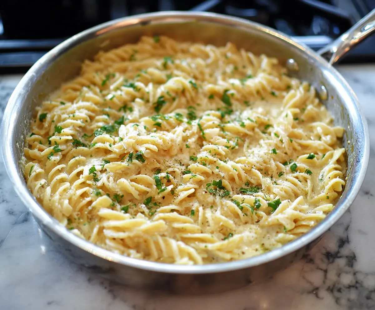 Delicious one pan garlic parmesan pasta served in a bowl, garnished with fresh herbs.