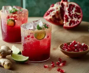 Refreshing Pomegranate Ginger Fizz cocktail with vibrant red pomegranate seeds and fresh ginger garnished in a stylish glass.