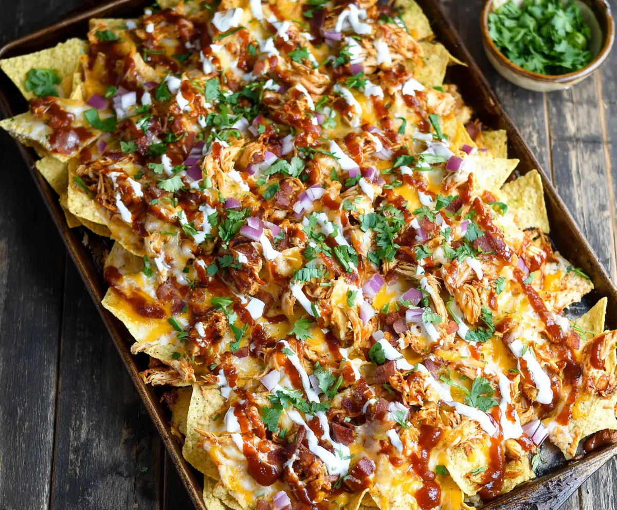 Delicious sheet pan BBQ chicken nachos topped with melted cheese and fresh cilantro.