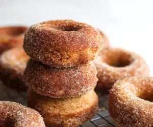 Delicious homemade sourdough apple cider donuts on a rustic plate with cinnamon sugar topping