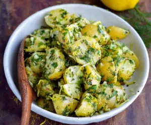 Fresh Lemon Herb Potato Salad garnished with herbs and lemon slices for a vibrant summer dish.