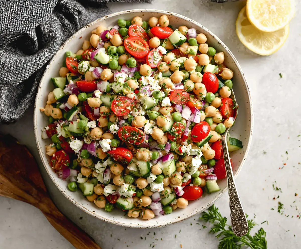 Colorful Mediterranean Pea Salad with fresh vegetables and herbs in a white bowl