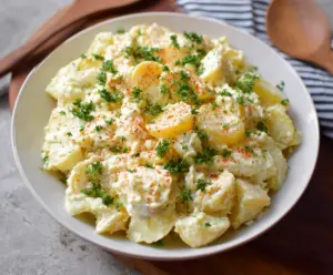 Creamy potato salad with fresh herbs and vegetables, perfect for summer picnics.