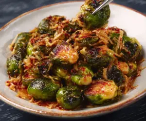 Delicious Red Lobster Brussels Sprouts garnished with fresh herbs on a white plate.